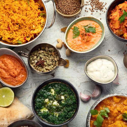 A variety of indian food in bowls on a table.