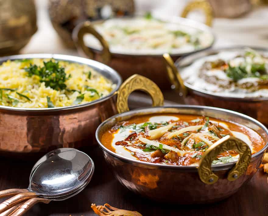 Catering spread with several bowls of food on a table.