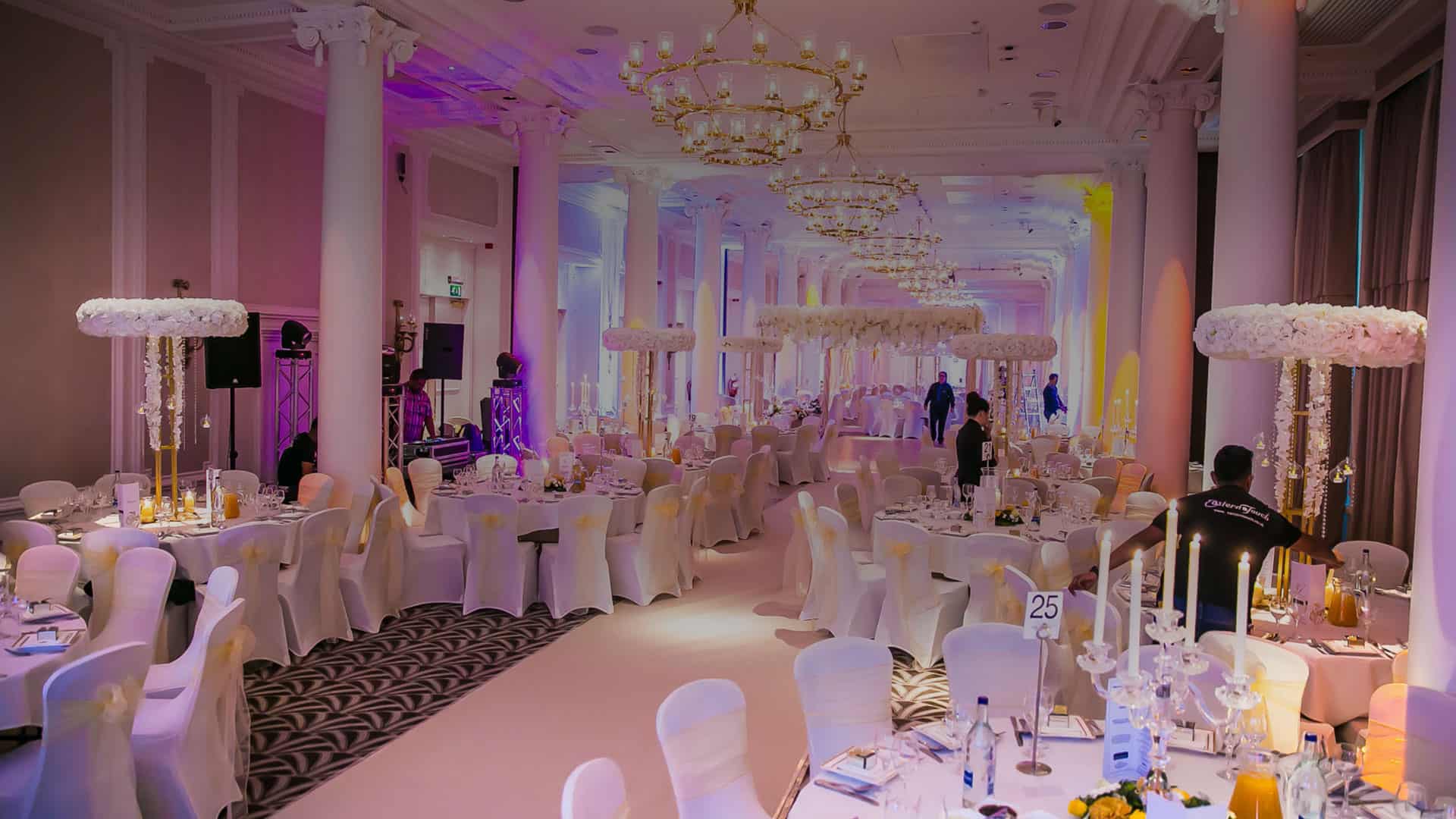 A large ballroom decorated for a wedding reception.