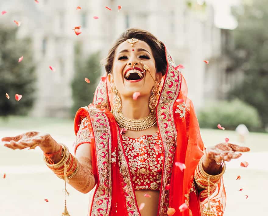 An indian bride throwing petals in the air at Hunton Park.