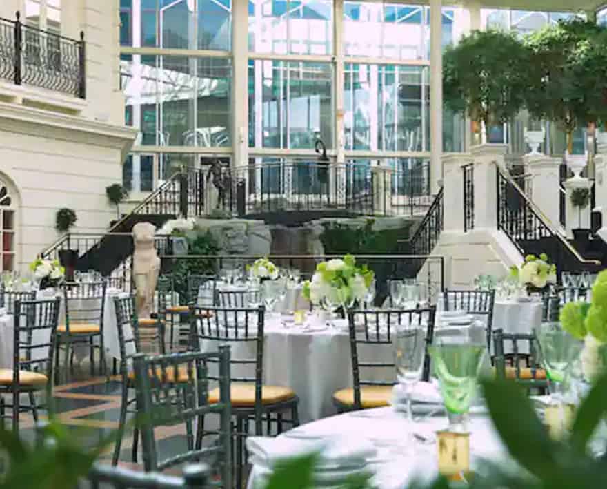 A wedding reception set up in a grand hotel ballroom.