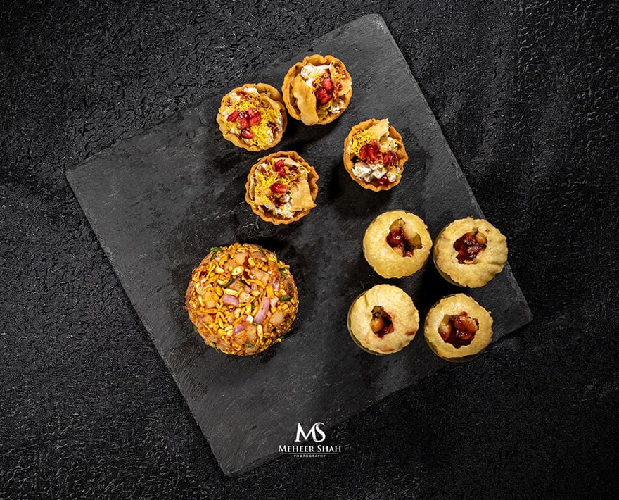 A tray of pastries on a black surface in a clay oven.